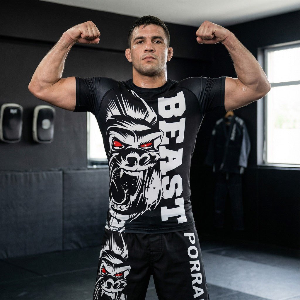 Male athlete wearing Porrada Fightwear men’s BJJ rash guard and grappling shorts while posing in an MMA gym.