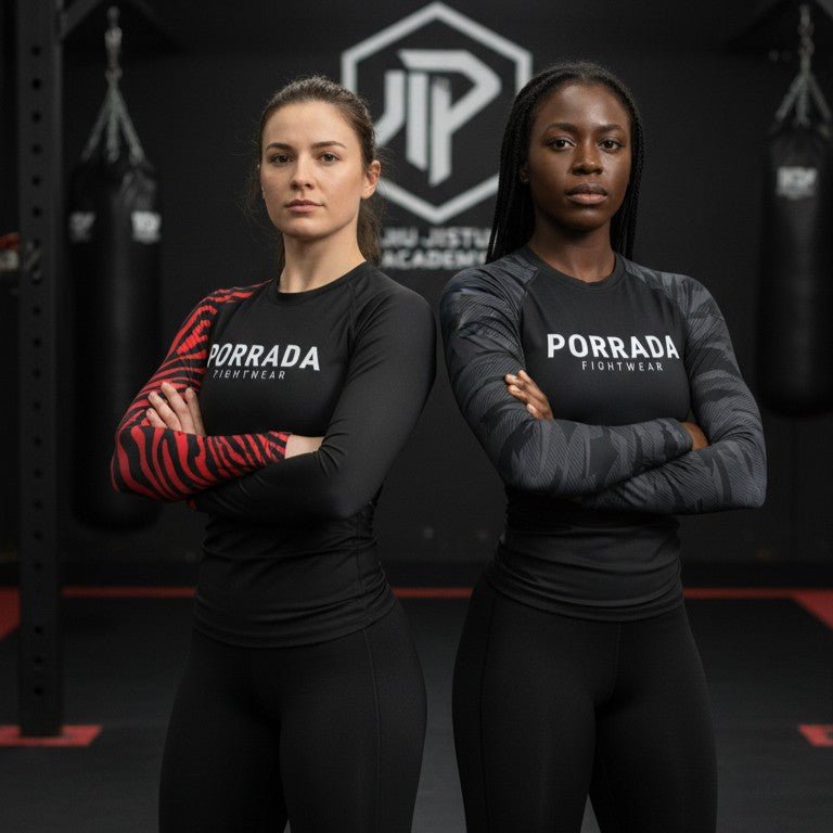 Two female athletes wearing Porrada Fightwear women’s BJJ rash guards and leggings while posing in a martial arts gym.