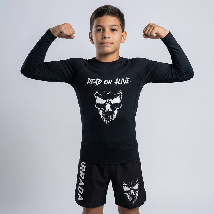 Kids’ black long-sleeve rash guard featuring a ‘Dead or Alive’ skull design, perfect for BJJ and MMA training