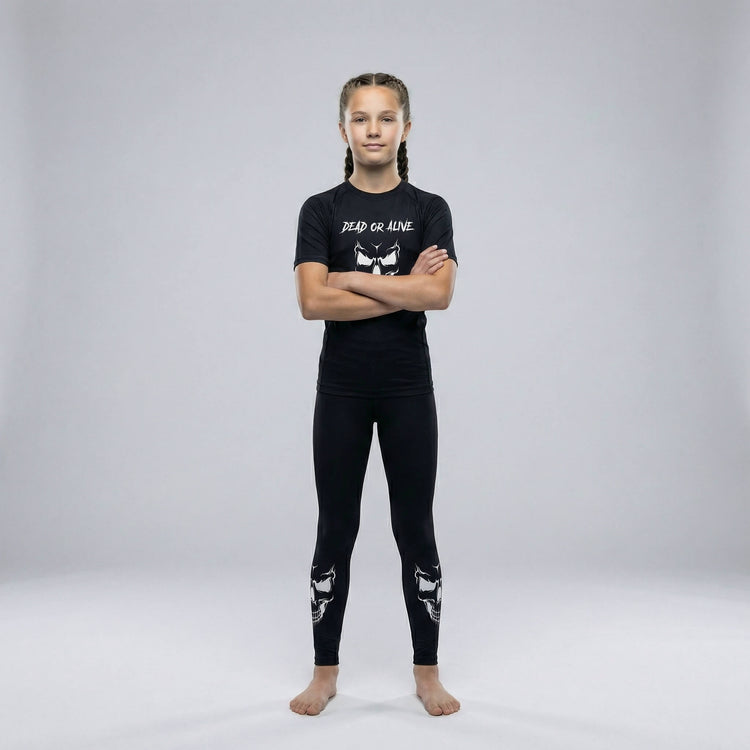 Kids’ grappling spats in black with a ‘Dead or Alive’ skull graphic for martial arts practice