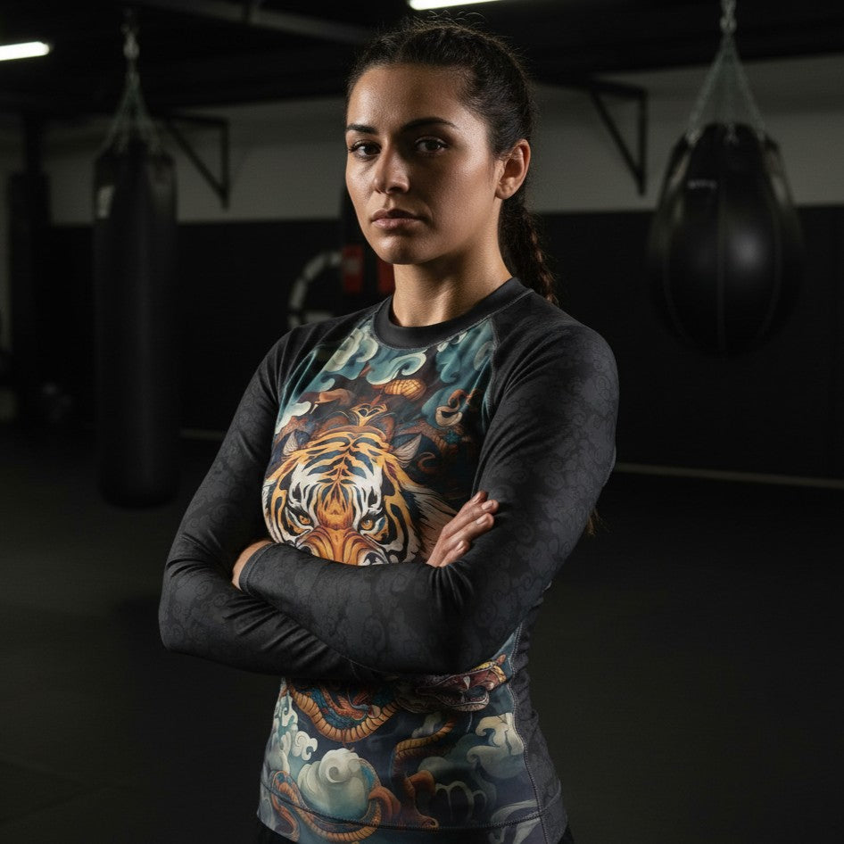 Female athlete wearing Porrada Fightwear women’s BJJ rash guards and leggings while posing in a MMA gym.